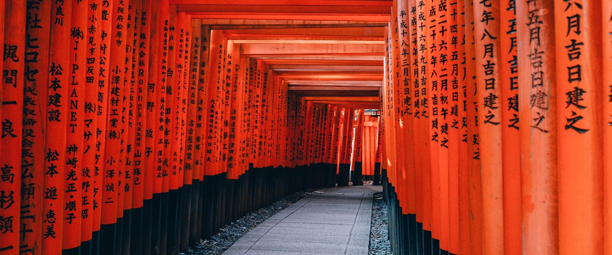 Row of red torii gates at Fushimi Inari Shrine in Kyoto leading through a bamboo forest