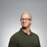 David L. Evans, Real Estate Law specialist, standing with arms crossed in front of office building